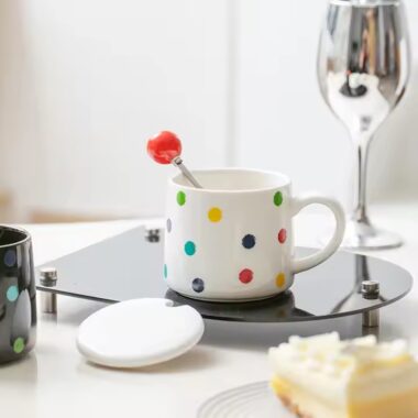 Colorful polka dot ceramic mug with lid and spoon for tea or coffee